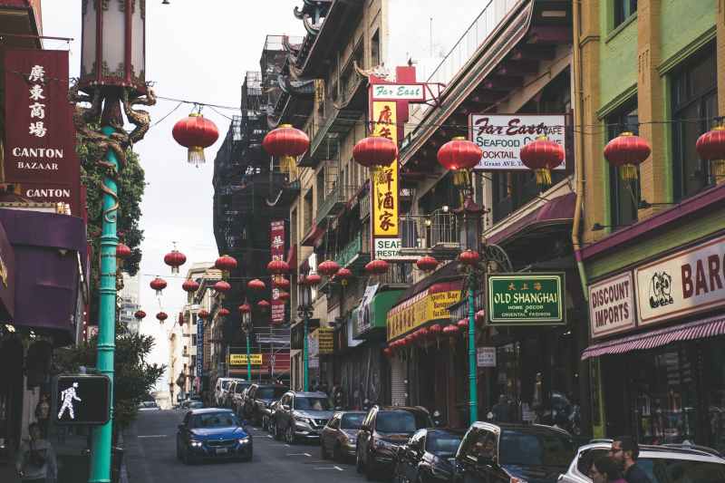 vehicles parked beside buildings under red chinese lanterns